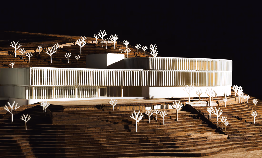 Scale model of Villa Aymore, with a curved white facade set into a terraced hillside.